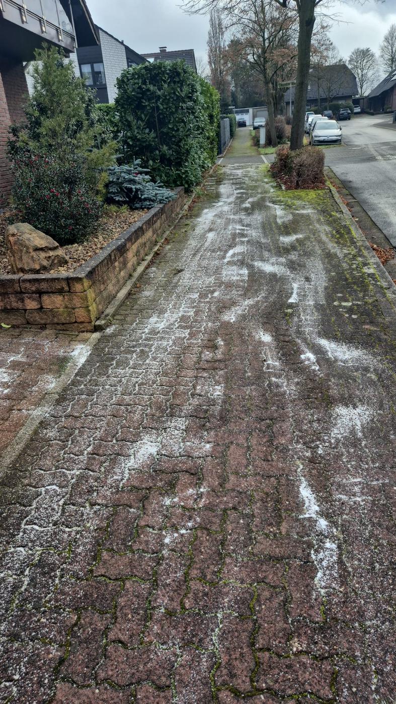 Gestreuter Gehweg an einer Wohnstraße im Winter